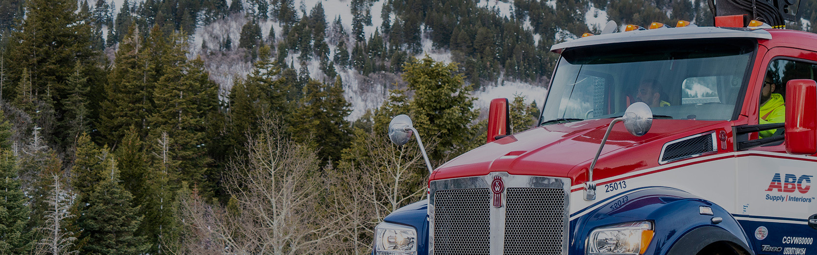 ABC Supply Interiors truck parked in front of mountain in background.