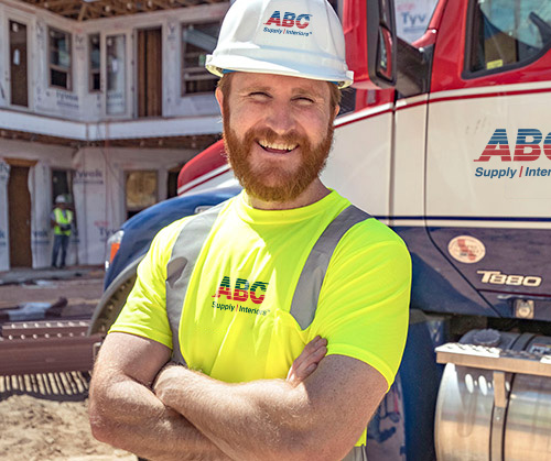 Delivery driver standing with arms crossed, smiling, facing camera